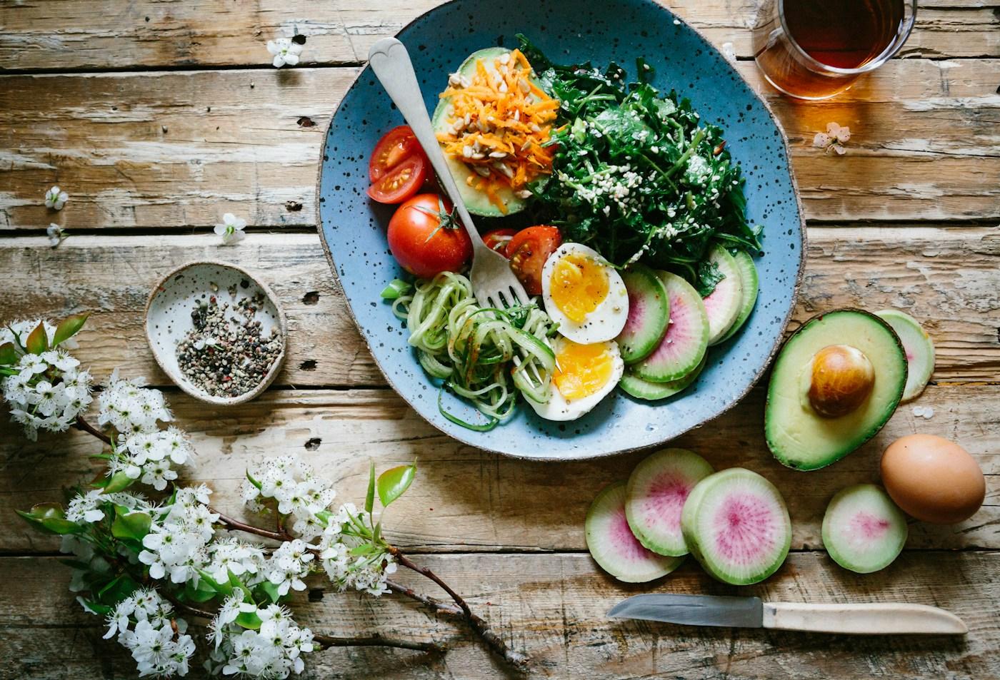 Prato azul com alimentos variados sobre uma mesa de madeira